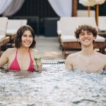 The Guy Flirts With A Girl In The Hot Tube. Couple Relaxing In T