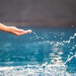 Closeup Image Of A Hand Splashing Water In The Pool