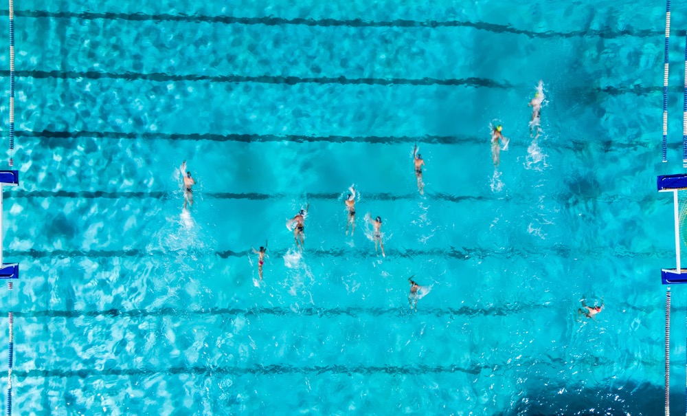 Group Of Swimmers Training In An Outdoor Pool Aerial View